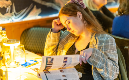 UCD alumna reading UCD Connections, the annual alumni magazine, at a UCD Alumni event.